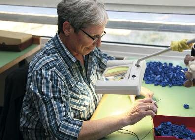 Mitarbeiterin bei der Montage blauer Kunststoffteile
